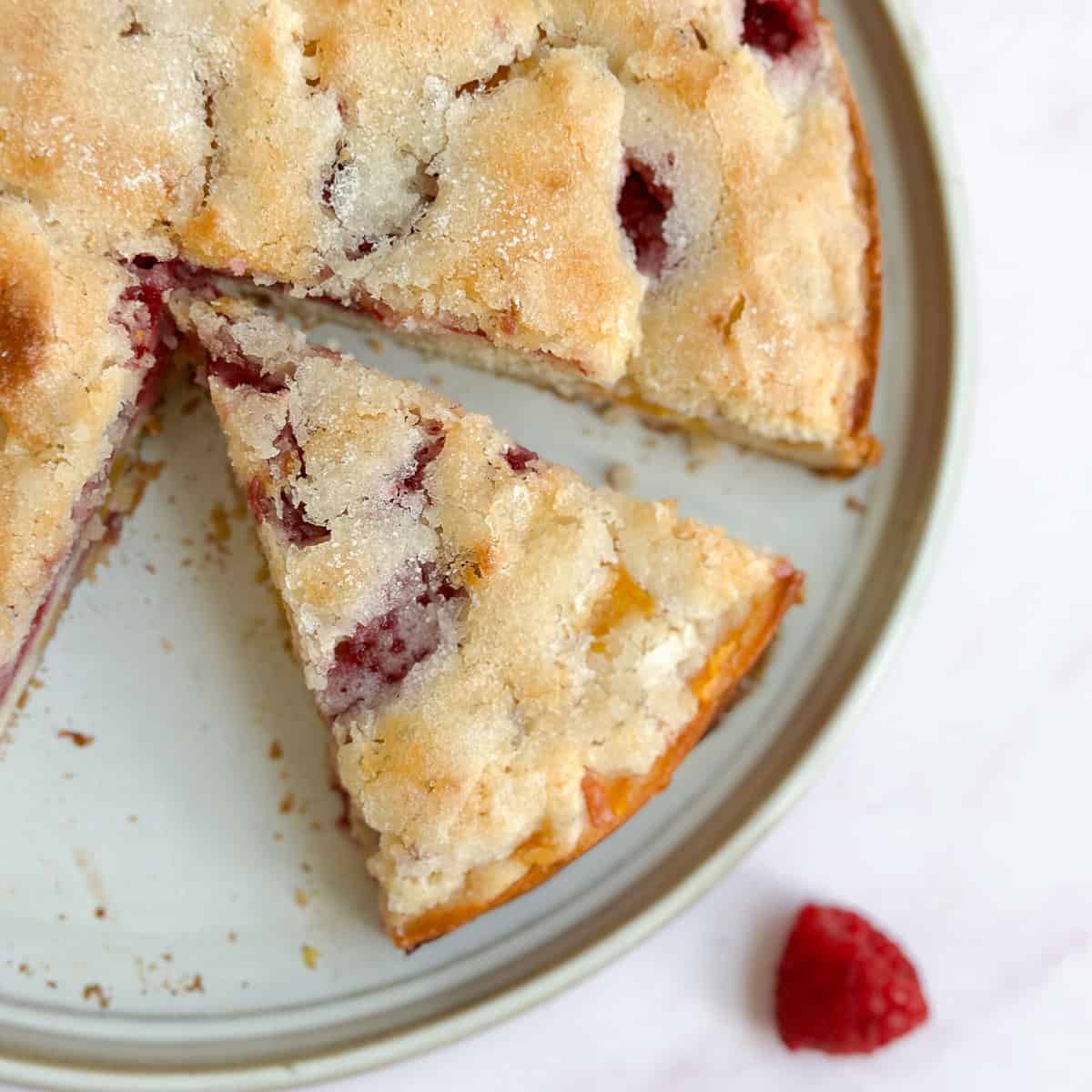 a slice of the raspberry peach cake separate from the rest of the cake.