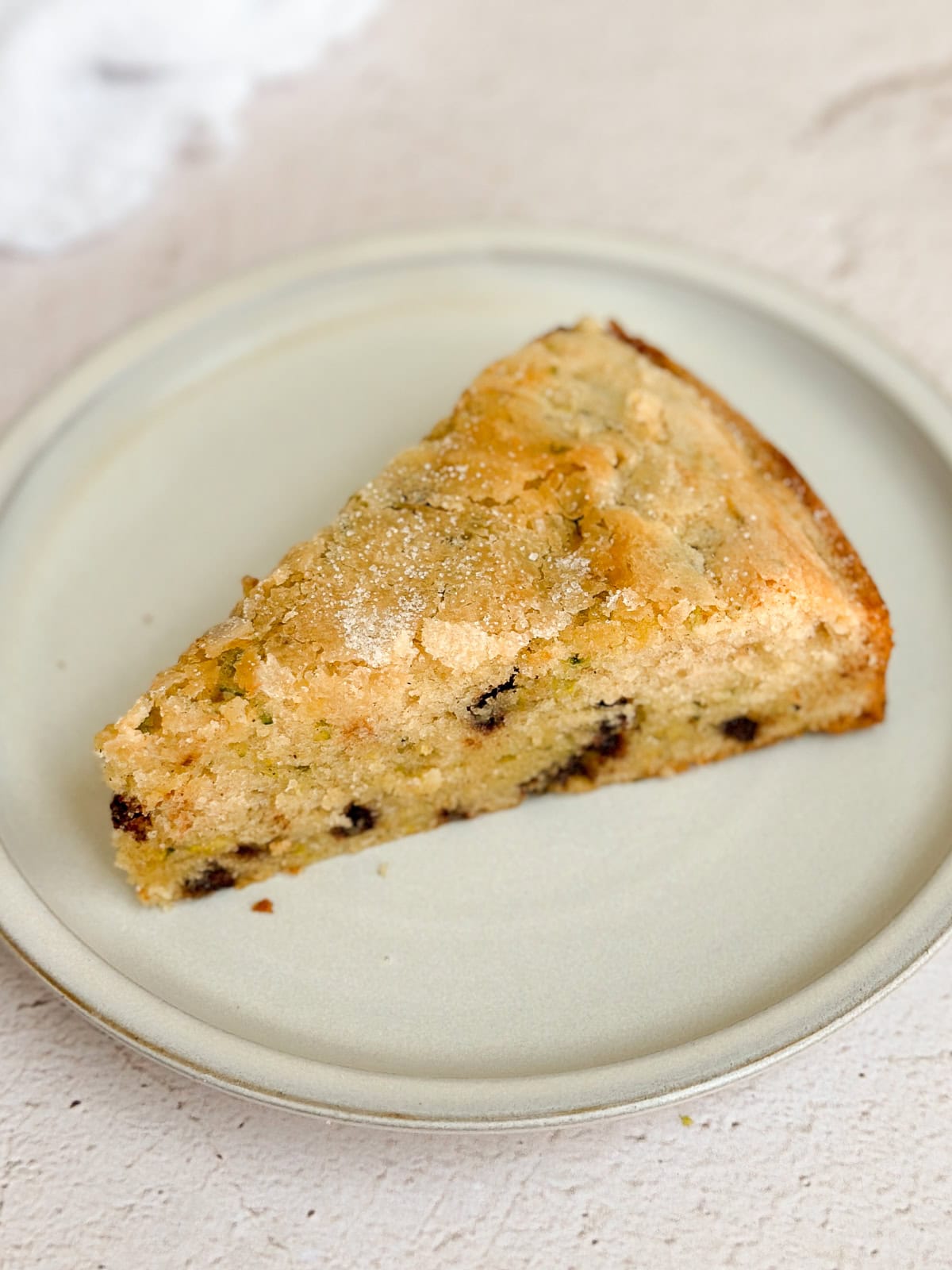 un morceau de gâteau aux courgettes et pépites de chocolat dans une assiette.