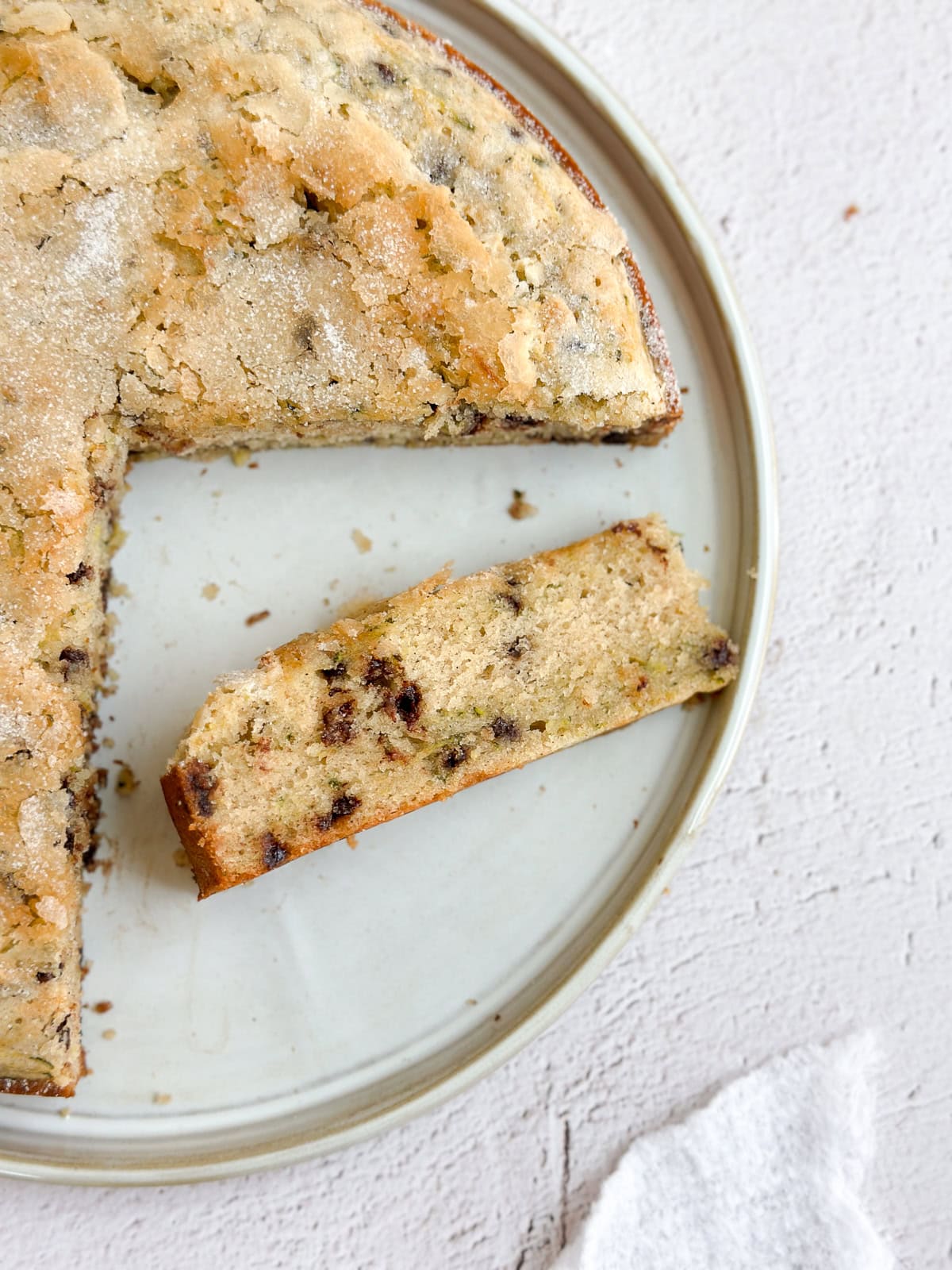 une tranche de gâteau aux courgettes et pépites de chocolat sur le côté pour voir l'intérieur.