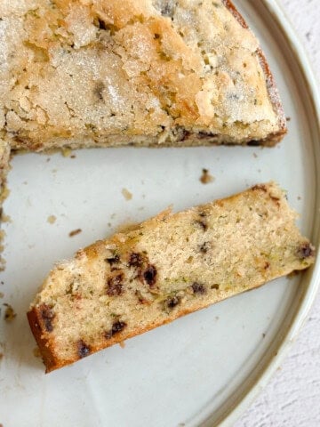 a slice of chocolate chip zucchini cake on it's side so you can see the inside.