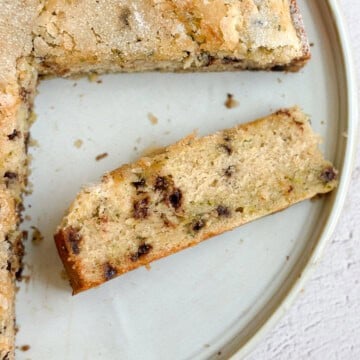 a slice of chocolate chip zucchini cake on it's side so you can see the inside.