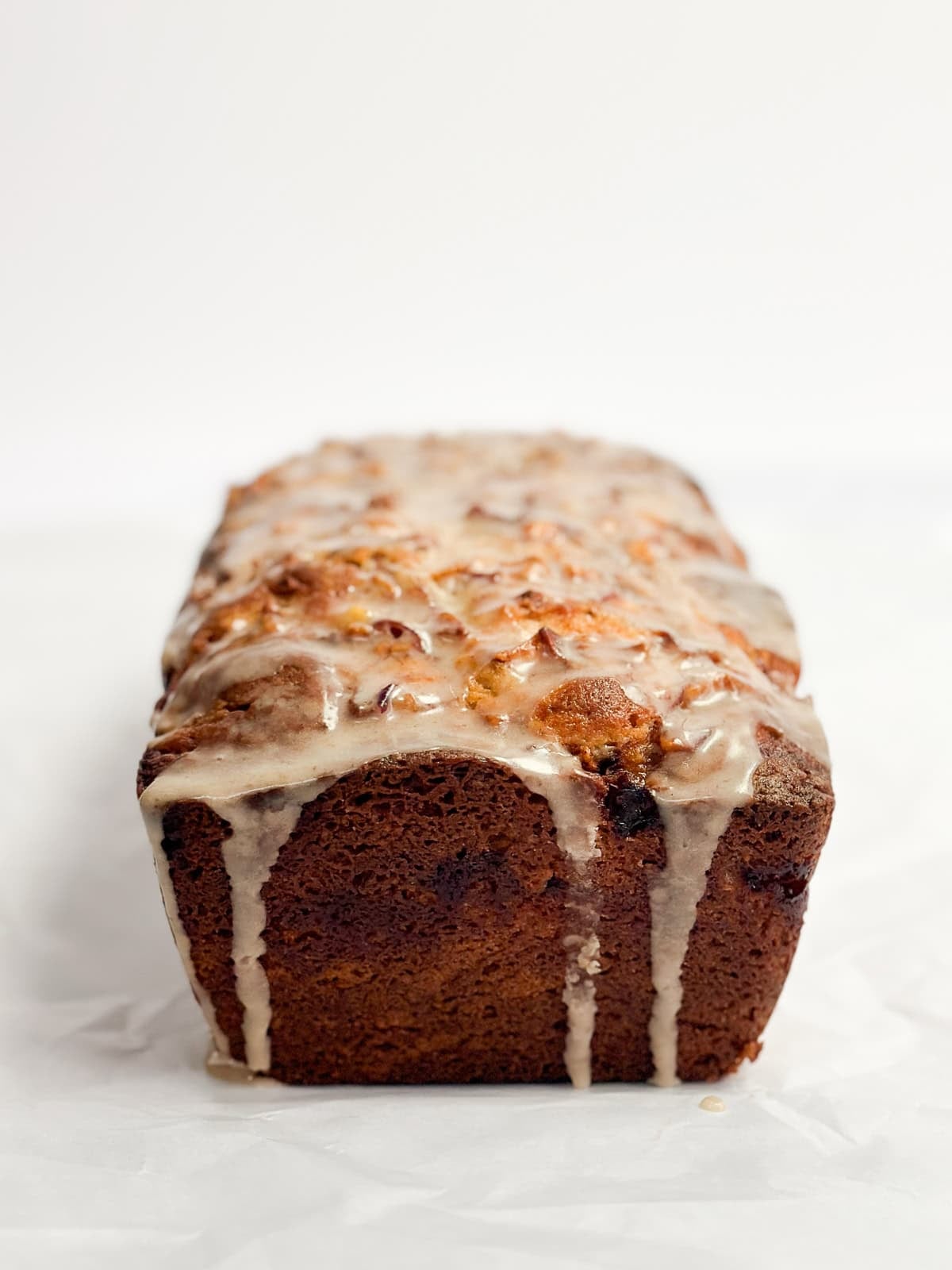 a side view of the whole peach loaf cake after its been glazed.