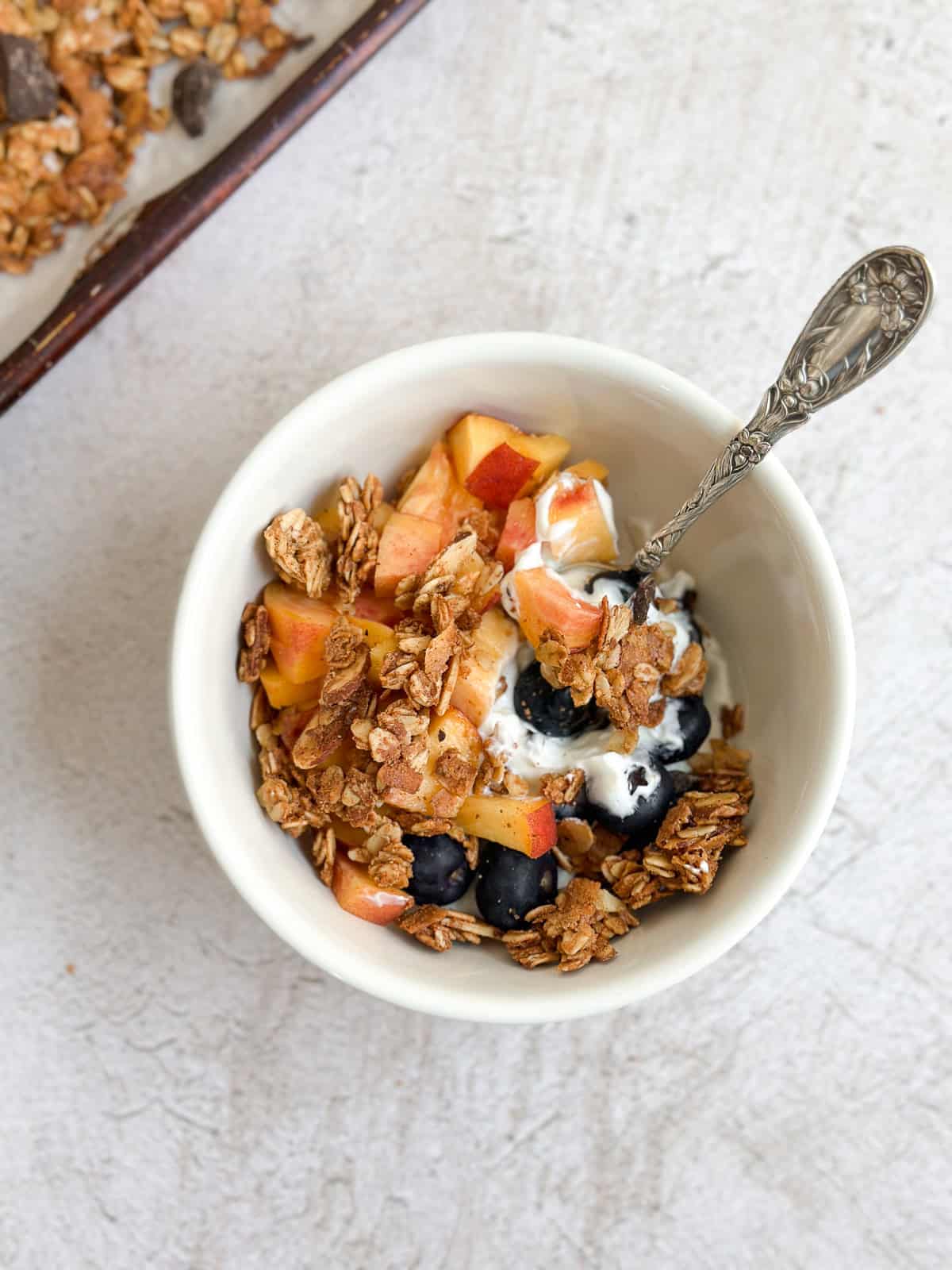 a handful of granola on top of a yogurt bowl.