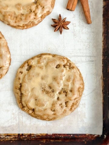 a few pumpkin spice latte cookies on a cookie sheet with some cinnamon sticks next to them.