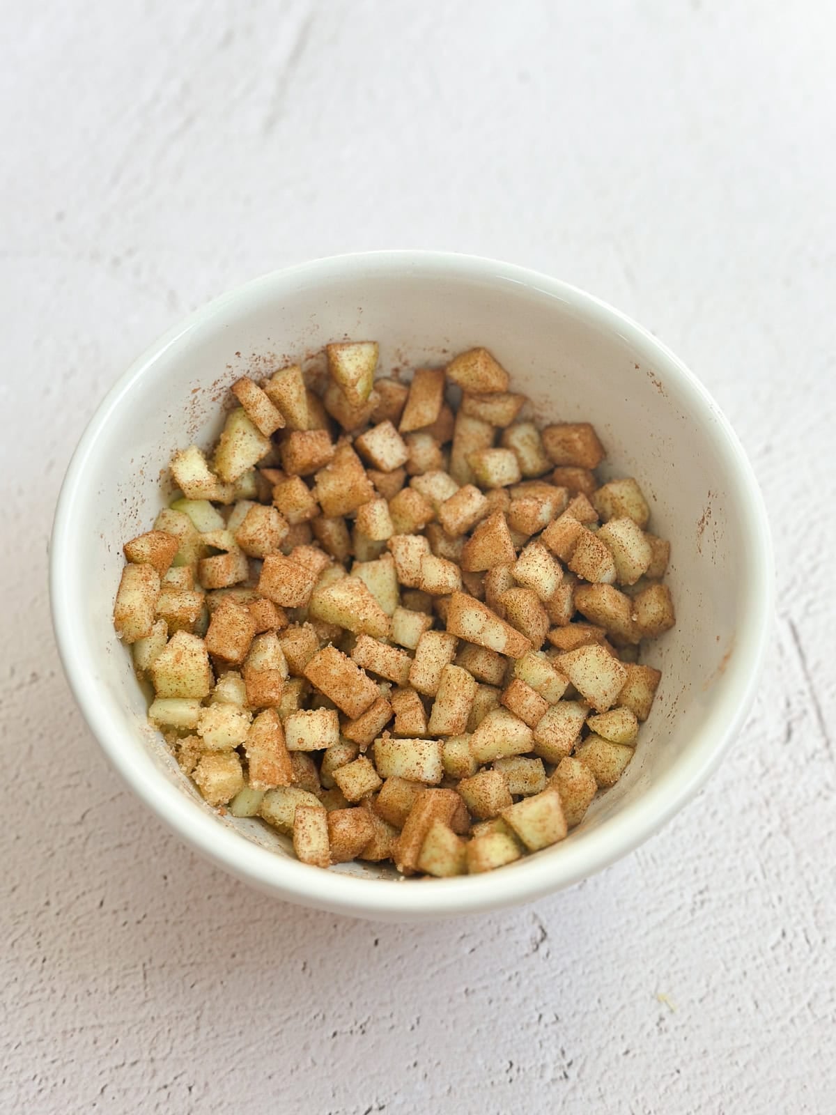 diced apples mixed with cinnamon and sugar.