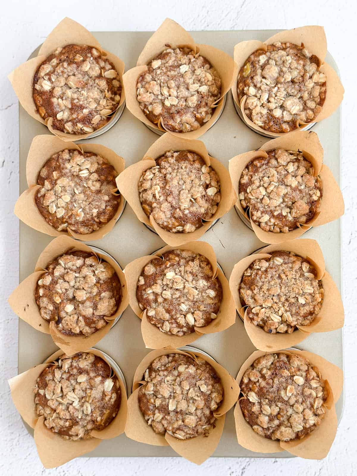 all 12 apple cinnamon oat muffins in the tin before topping with the glaze.