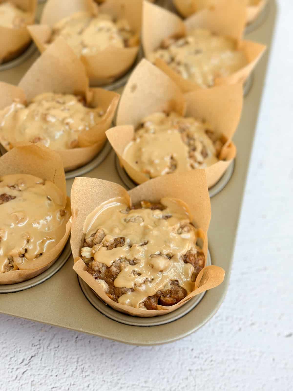 a side view of the apple cinnamon oat muffins in the muffin tin.