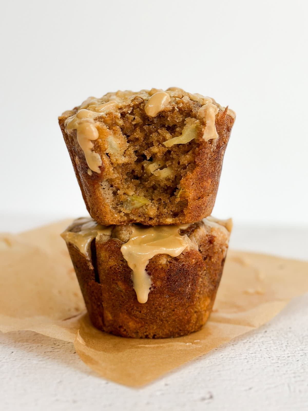 2 muffins à la cannelle et aux pommes empilés l'un sur l'autre.