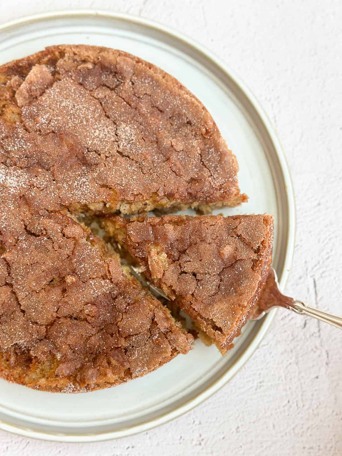 a cake spatula pulling a slice of this easy apple oatmeal cake out from the whole cake.