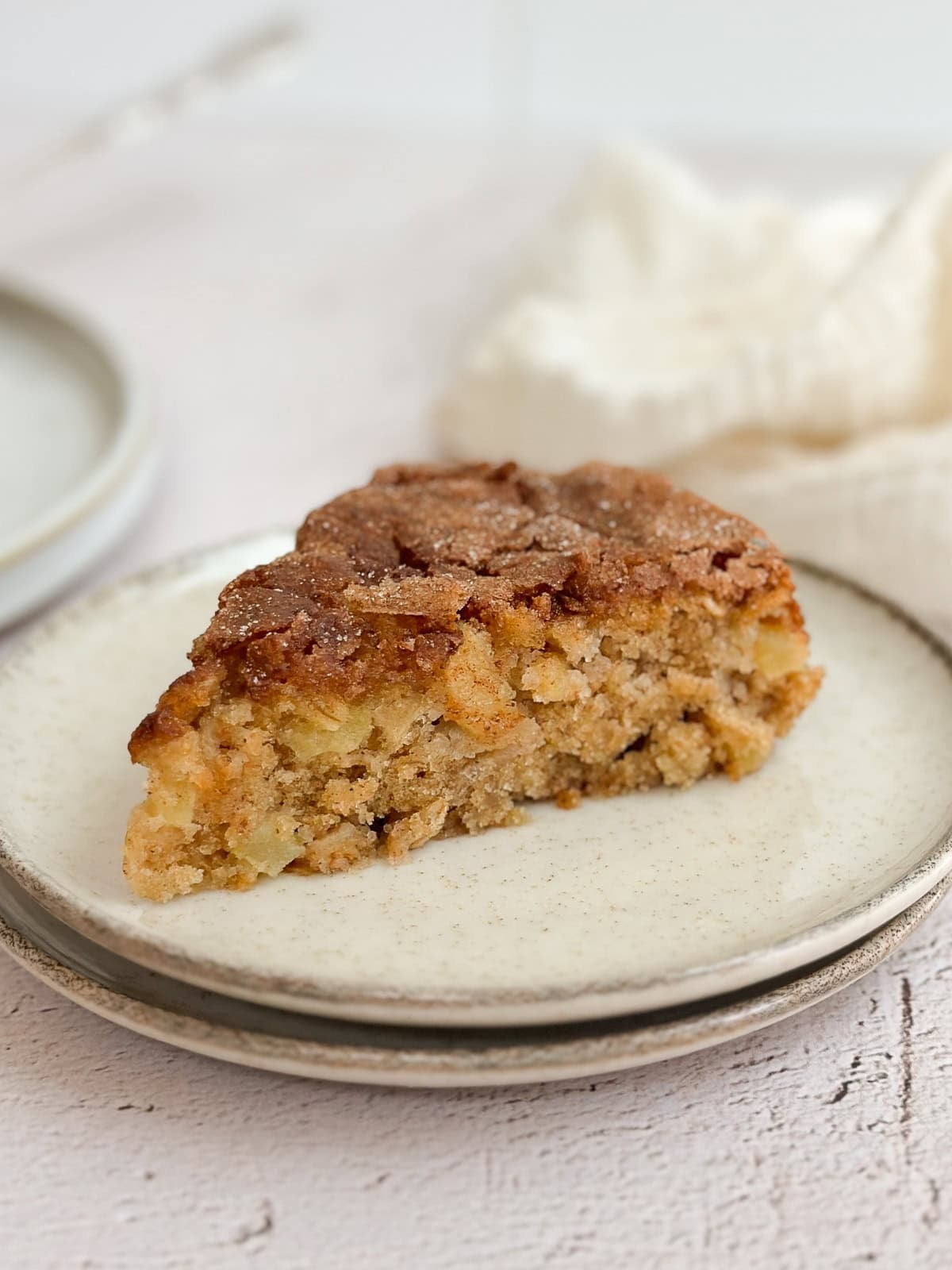 a side view of a slice of cake so you can see the texture and all the apples inside.