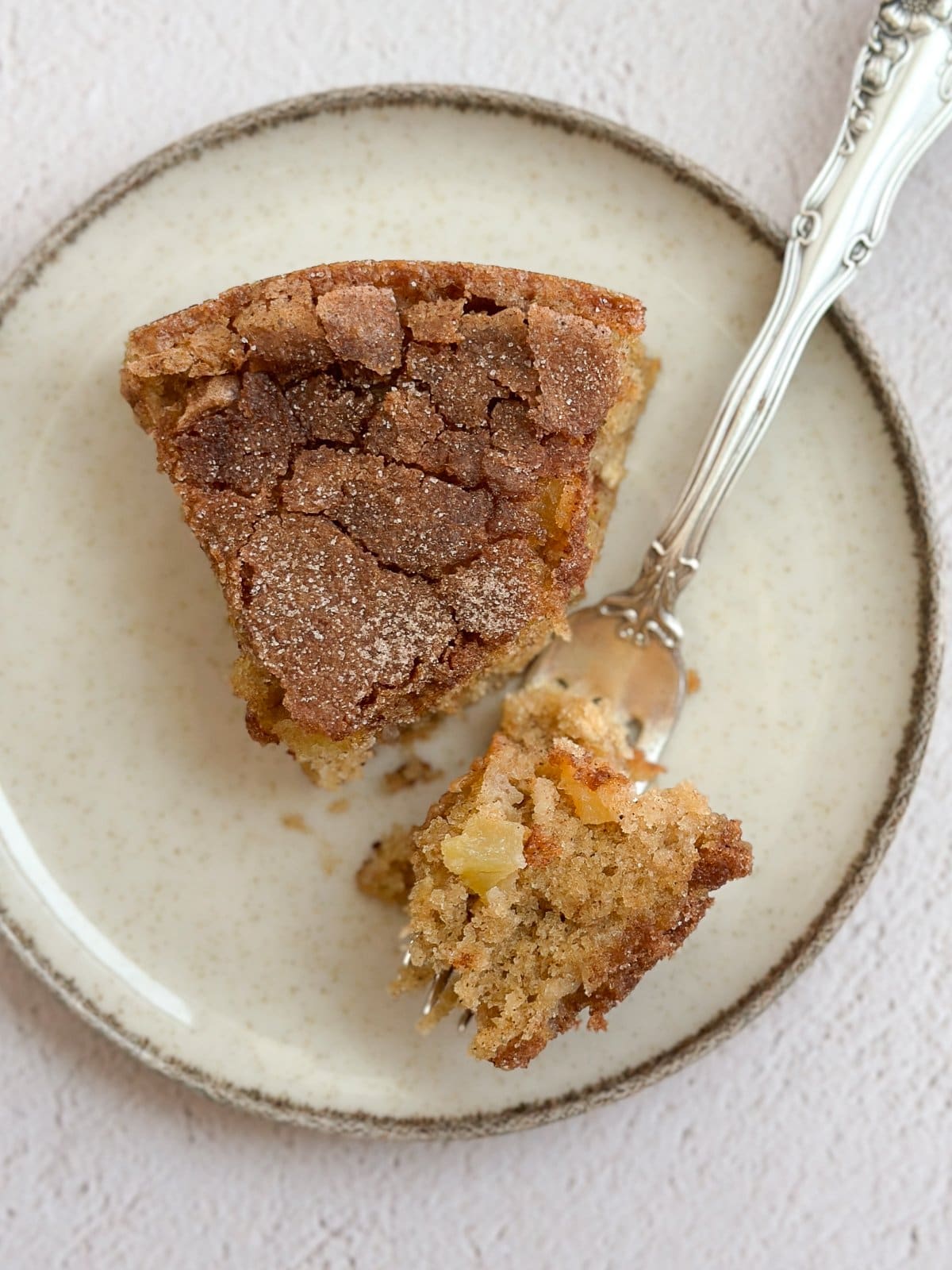une seule tranche de ce gâteau facile aux pommes et flocons d'avoine sur une assiette avec une bouchée sur une fourchette.