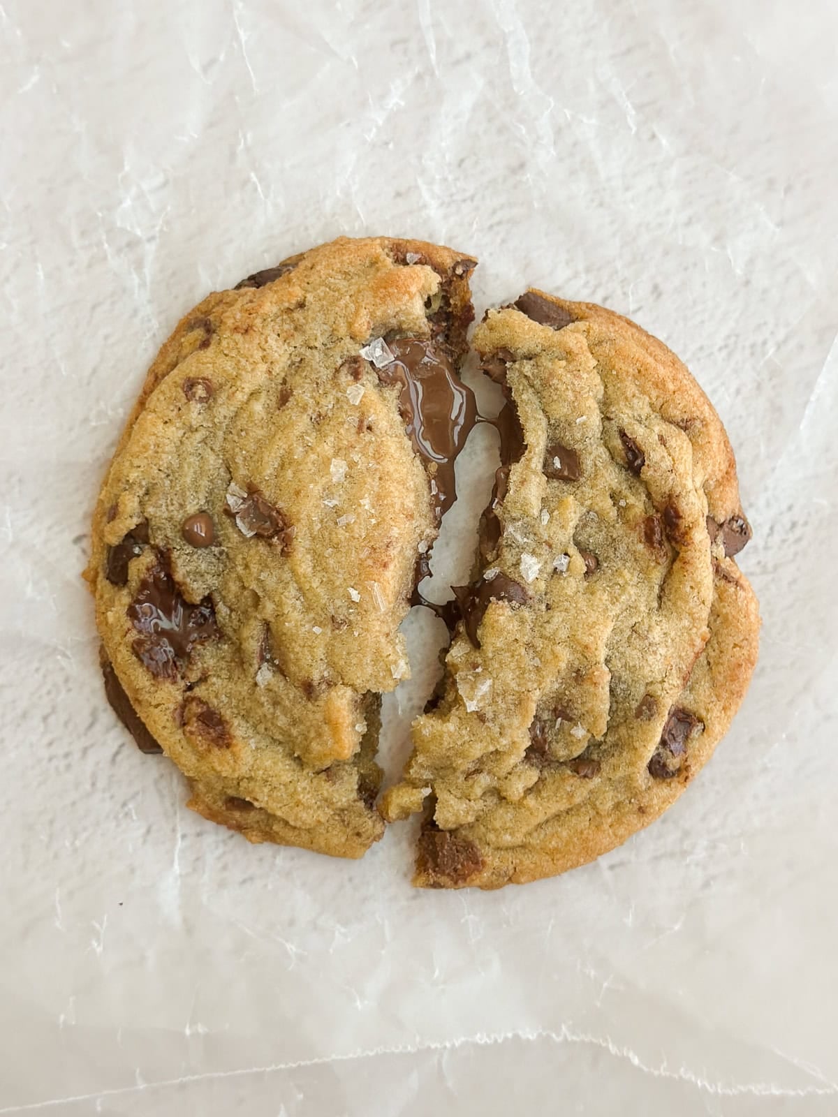 a close up of a fresh cookie with melty chocolate oozing out.