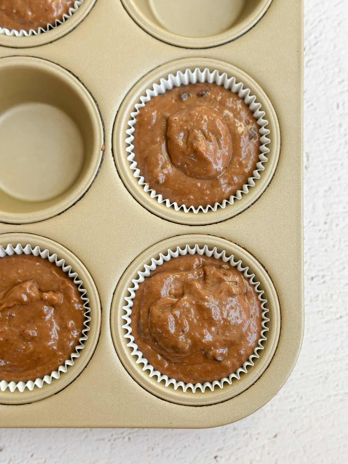 a close up of muffin batter in the cups before baking.