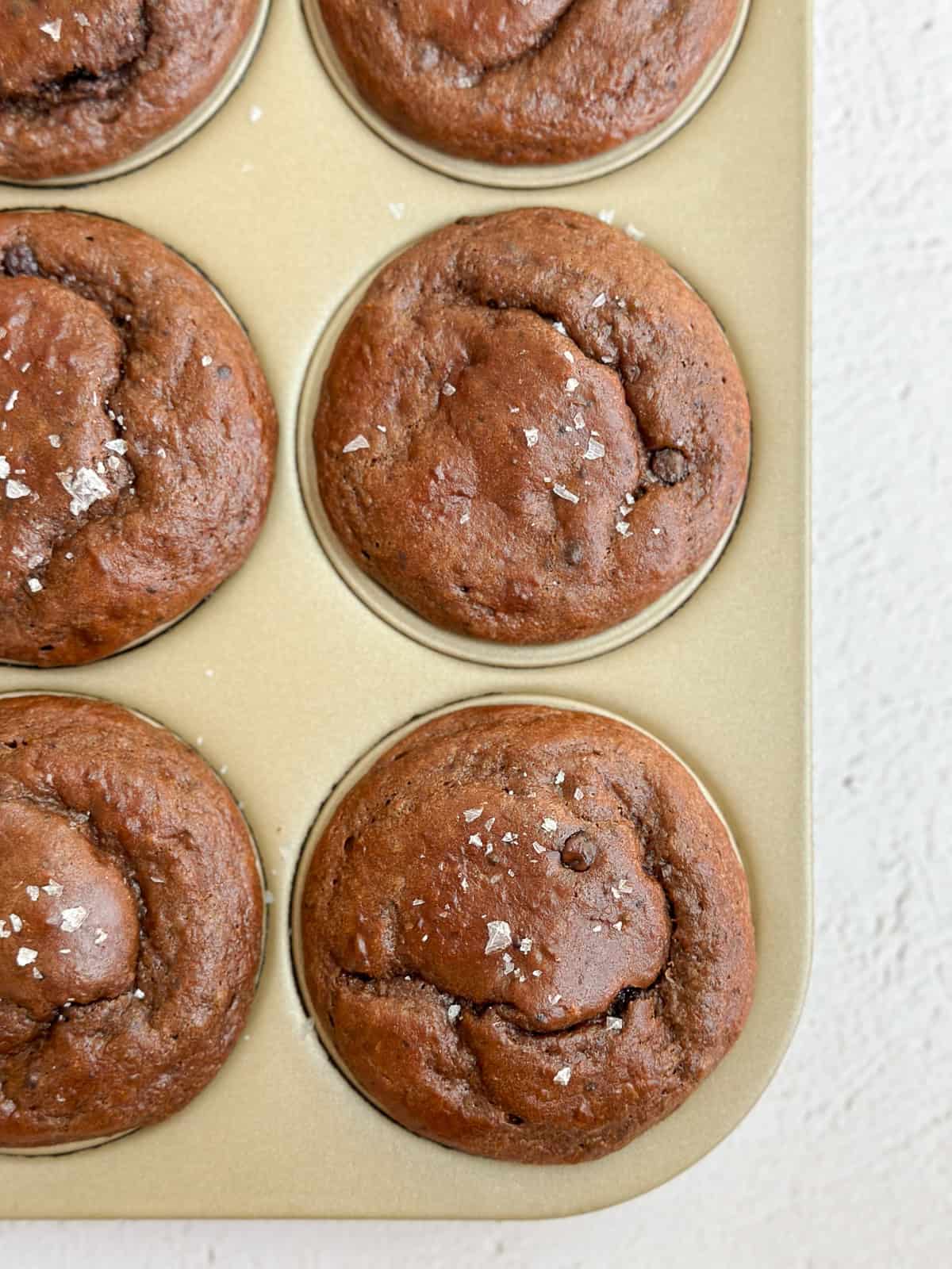 Quelques muffins protéinés au chocolat dans un moule à pâtisserie.