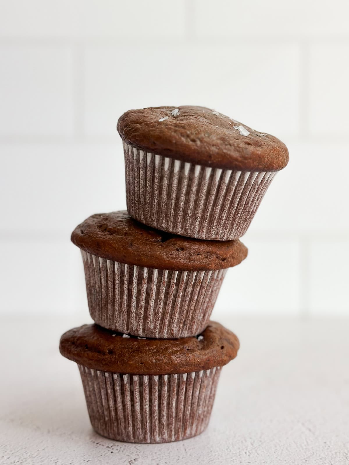 3 muffins protéinés au chocolat empilés les uns sur les autres.