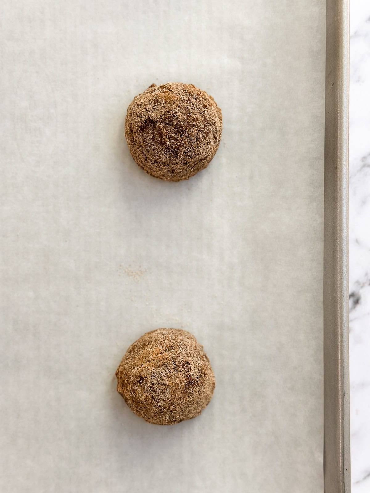 cookie dough balls scooped and rolled in cinnamon and sugar.