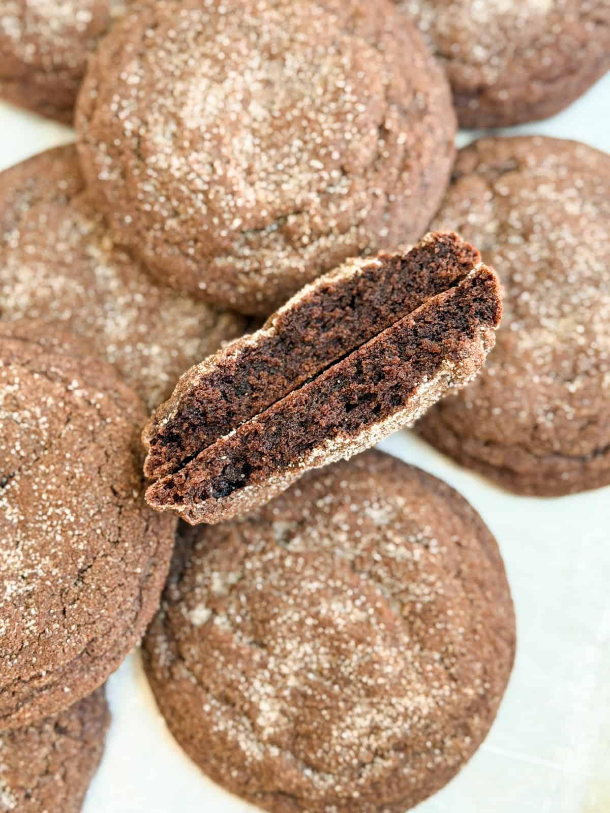 a chocolate snickerdoodle broken in half to see the inside texture.