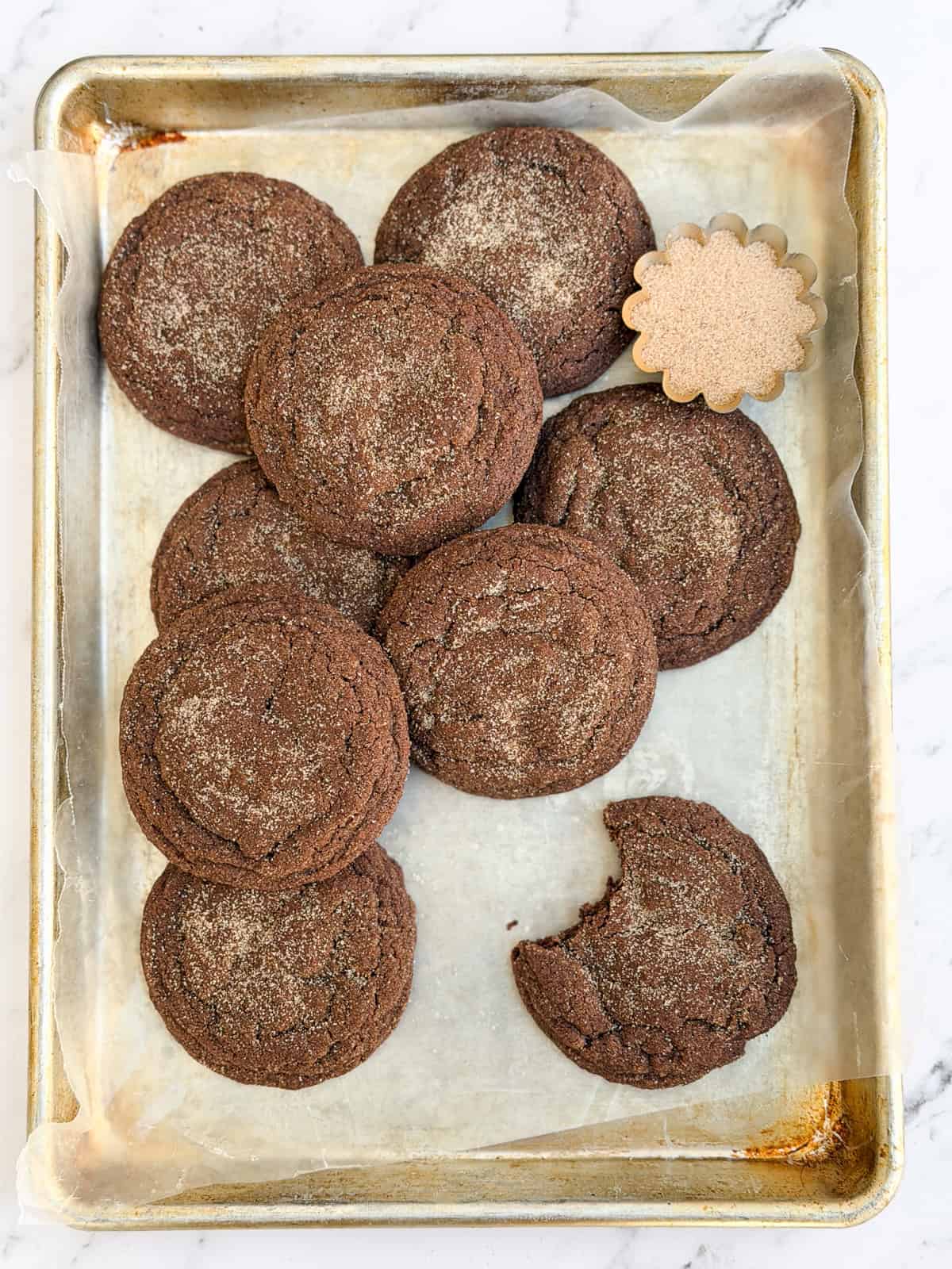 a bite missing from a chocolate snickerdoodle cookie.
