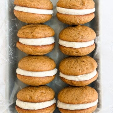 a bunch of gingerbread whoopie pies stacked together.