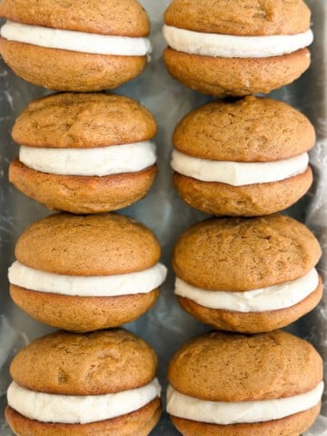 a bunch of gingerbread whoopie pies stacked together.