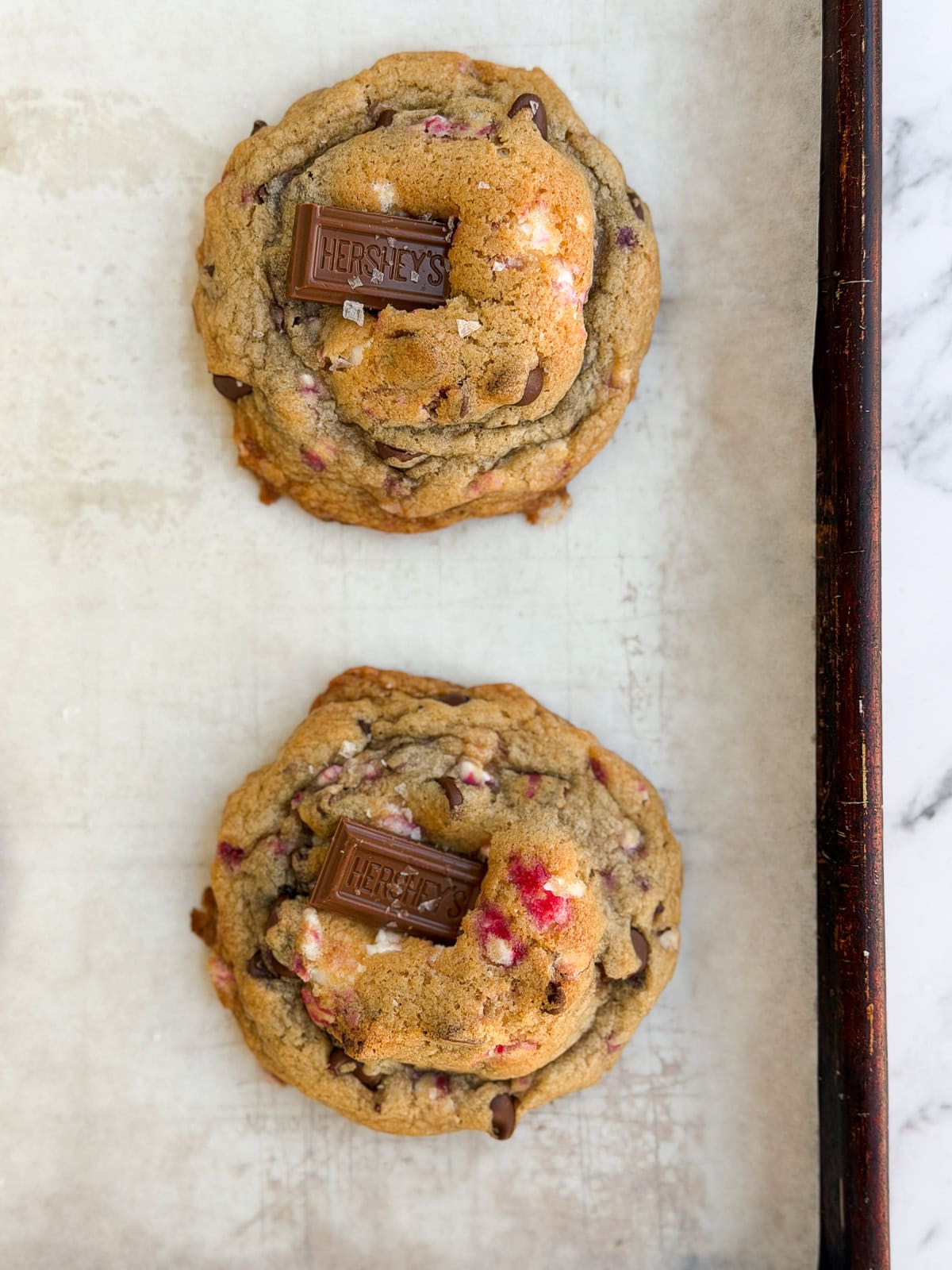 cookies right after baking with the hershey bar placed on top.