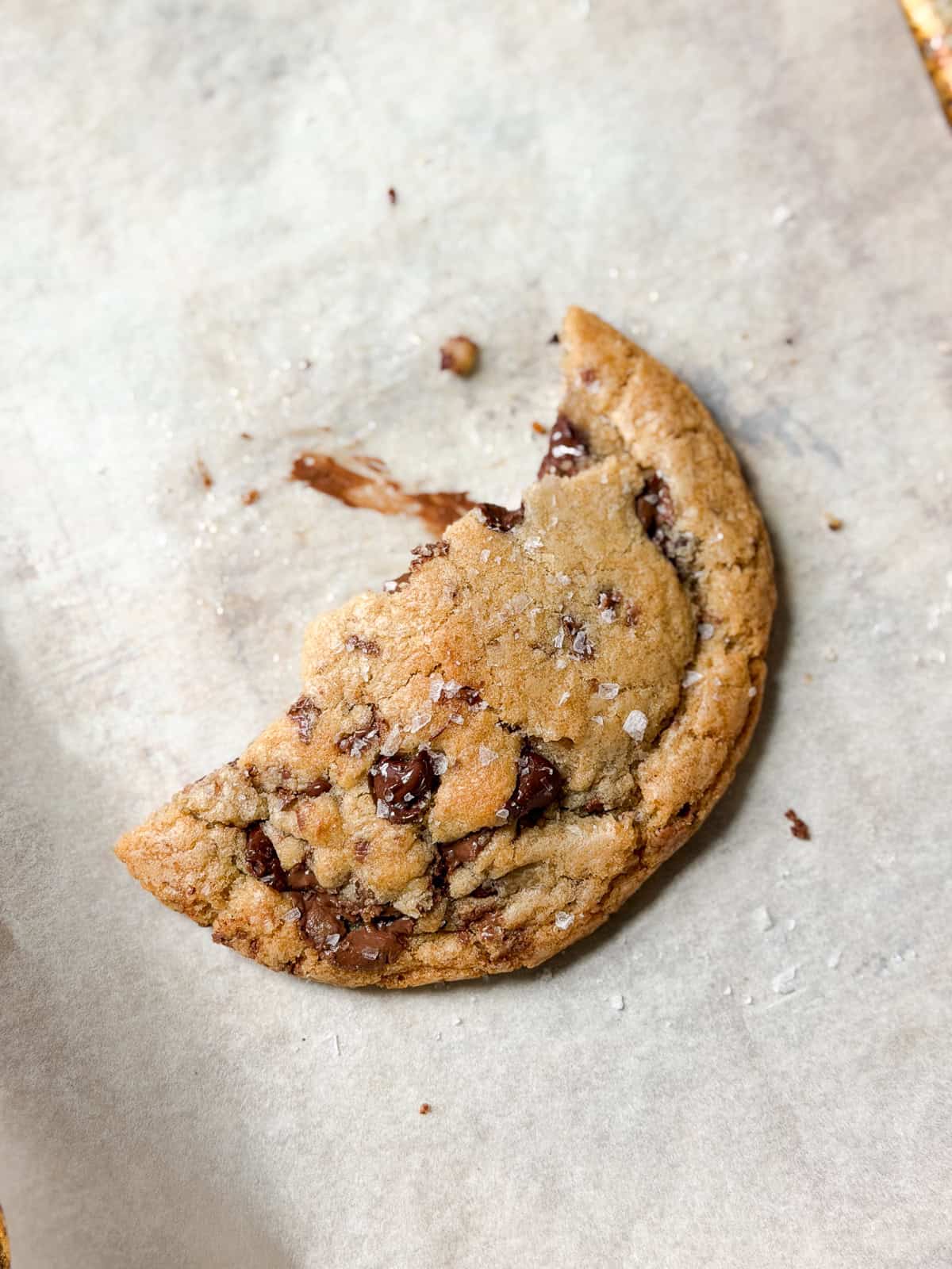 a broken piece of a single serve chocolate chip cookie with chocolate smeared.
