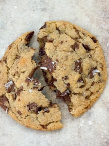 a single serve chocolate chip cookie broken in half.