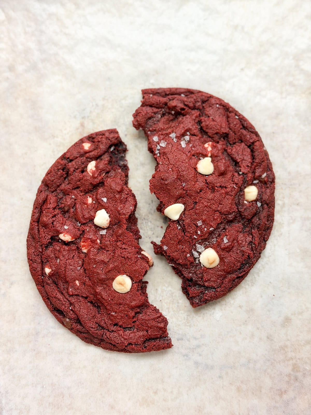 a single serve red velvet cookie broken in half.