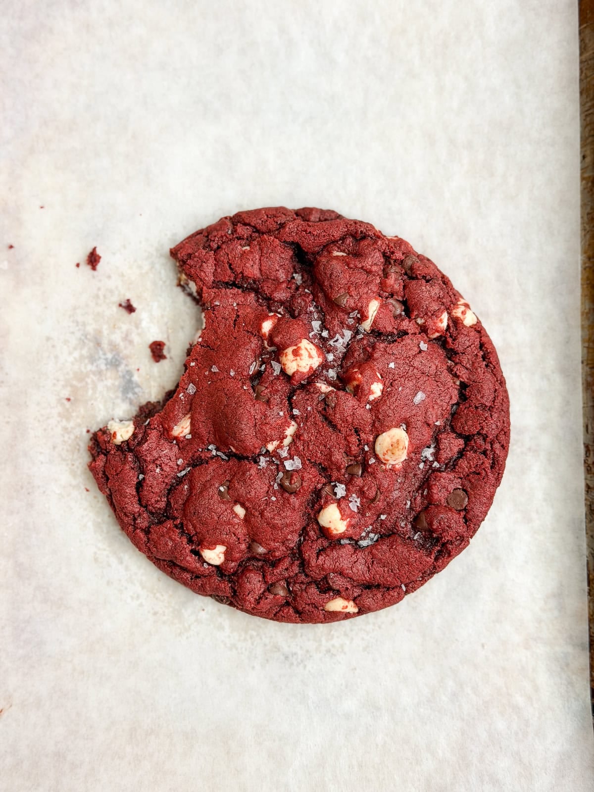a single serve red velvet cookie with a bite missing.