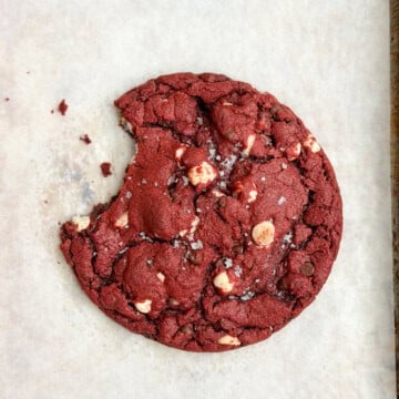 a single serve red velvet cookie with a bite missing.