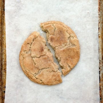 a single serve snickerdoodle cookie broken in half.