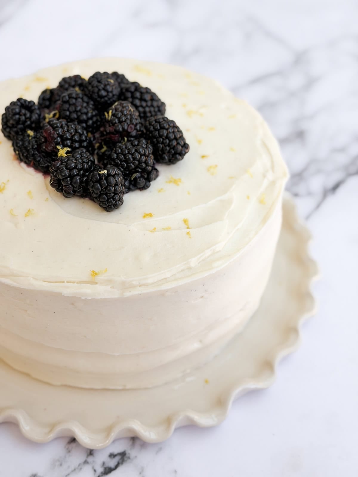 cake finished being frosted and topped with fresh blackberries.