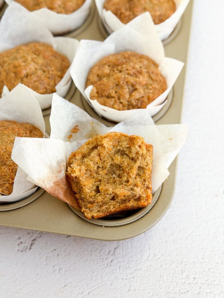 a close up of a banana carrot muffin with a bite missing to see the inside texture.