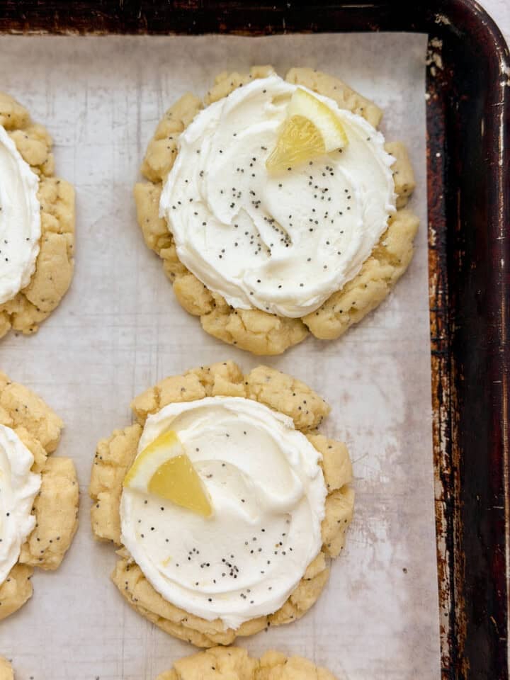 a close up of a few lemon poppyseed cookies on a baking sheet.