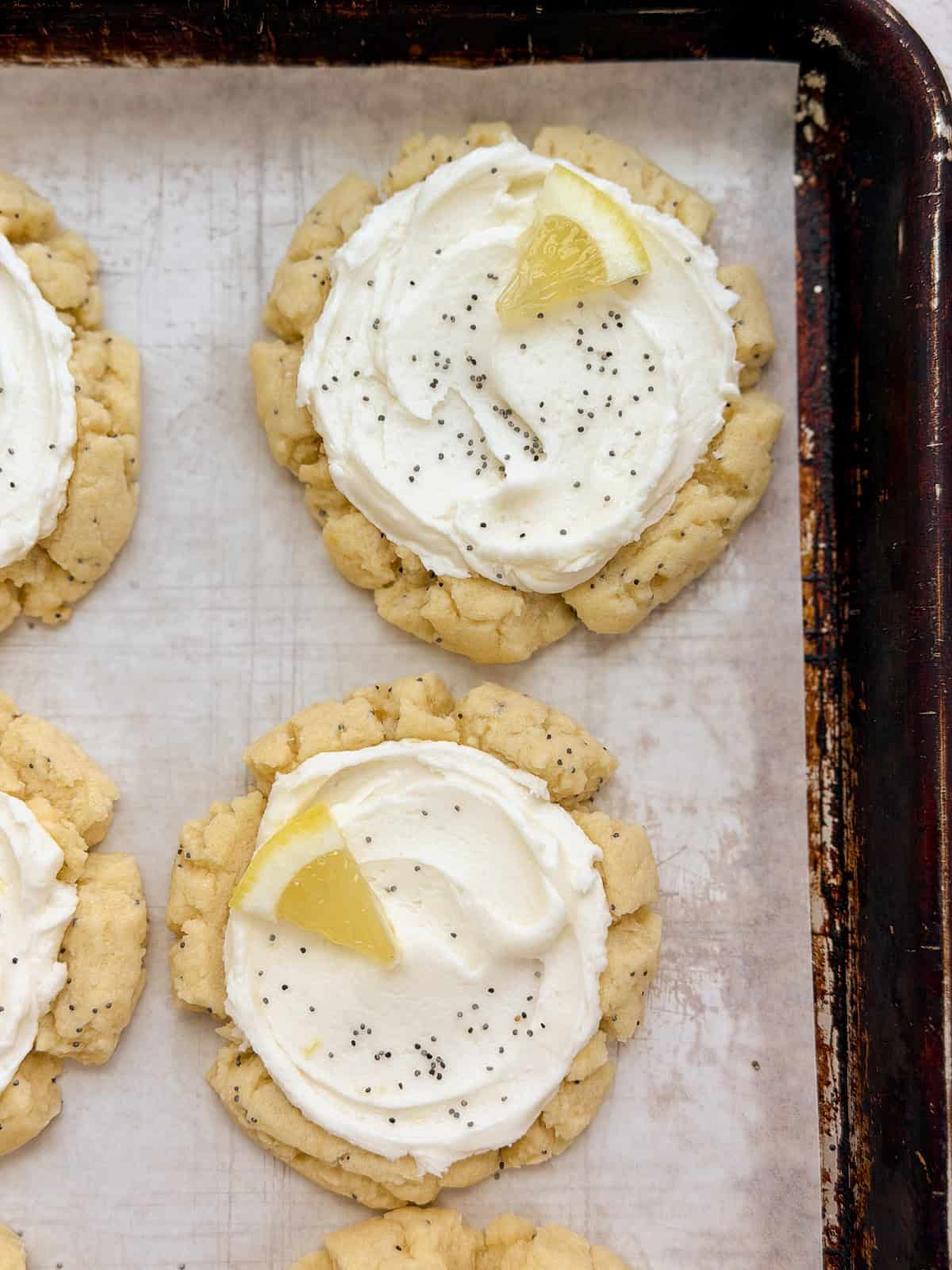 a close up of a few lemon poppyseed cookies on a baking sheet.