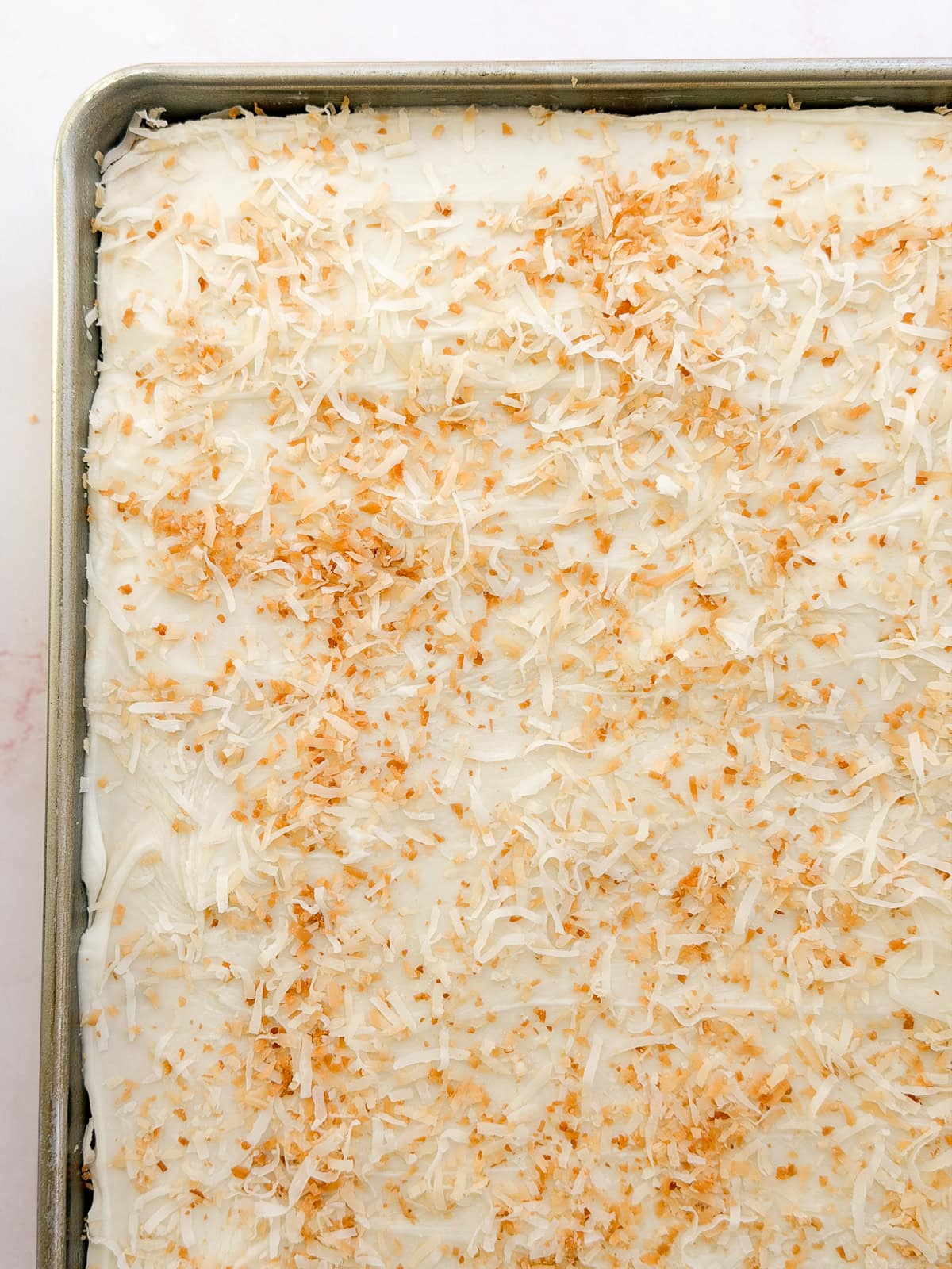 a close up of the coconut texas sheet cake in the pan before cutting.