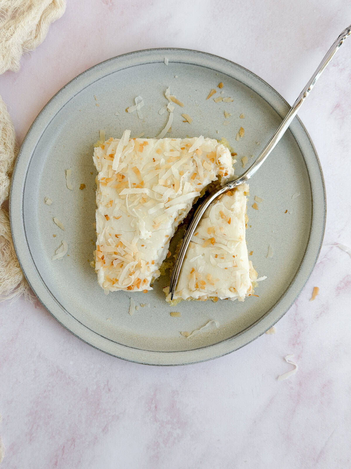 a fork cutting through a slice of coconut texas sheet cake.
