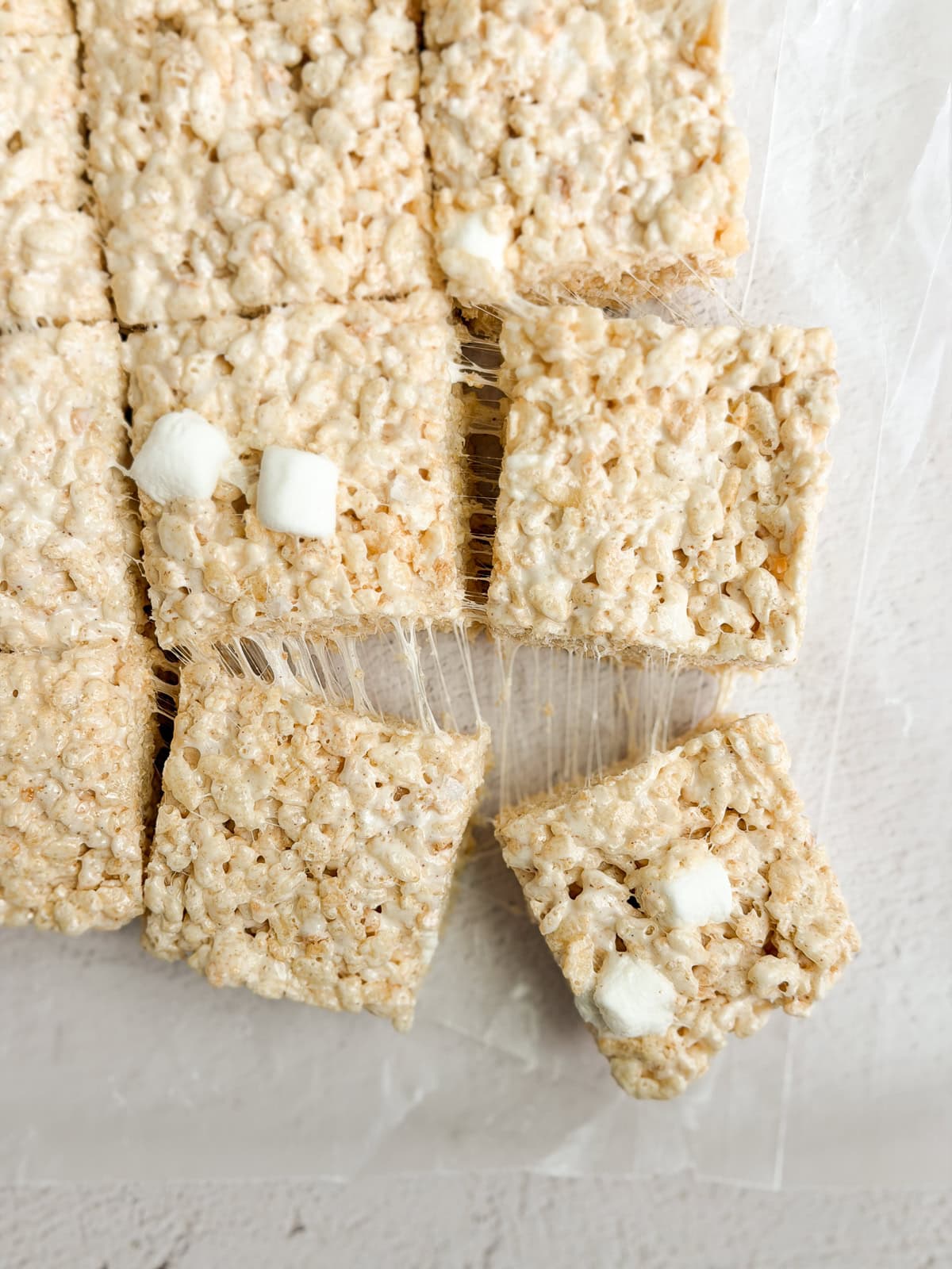 Brown butter rice krispies treats being cut into squares.