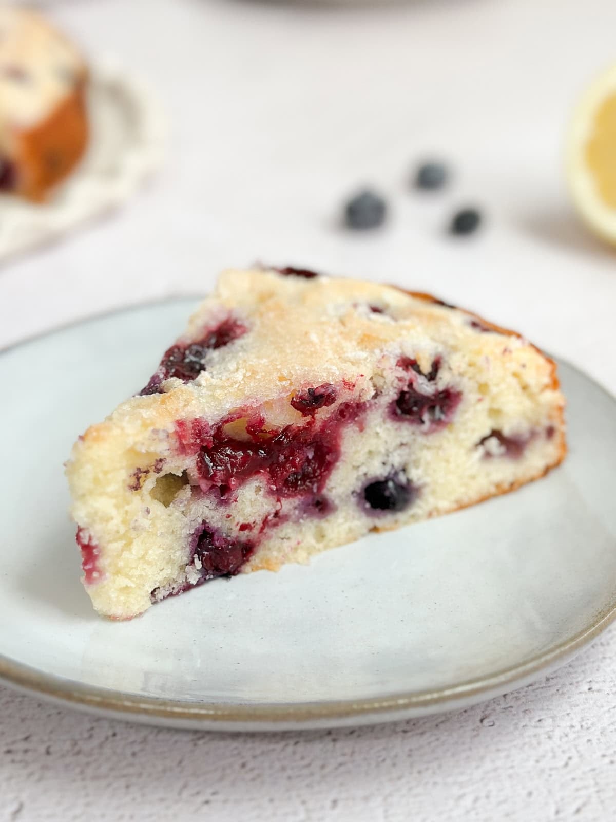 a single slice of lemon blueberry sour cream cake on a plate.