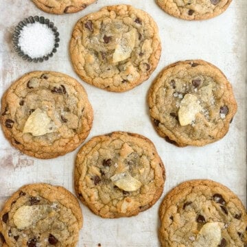 a bunch of chocolate chip potato chip cookies with a little salt on the side.