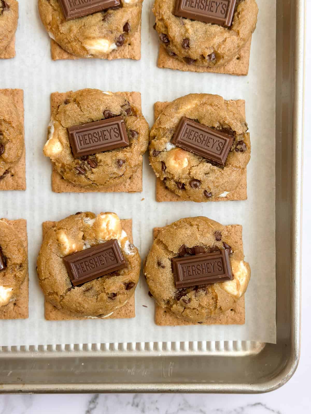 some of the graham cracker smore cookies on a baking sheet.