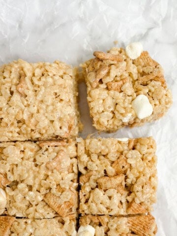 cinnamon toast crunch marshmallow treats cut into squares with one being pulled.