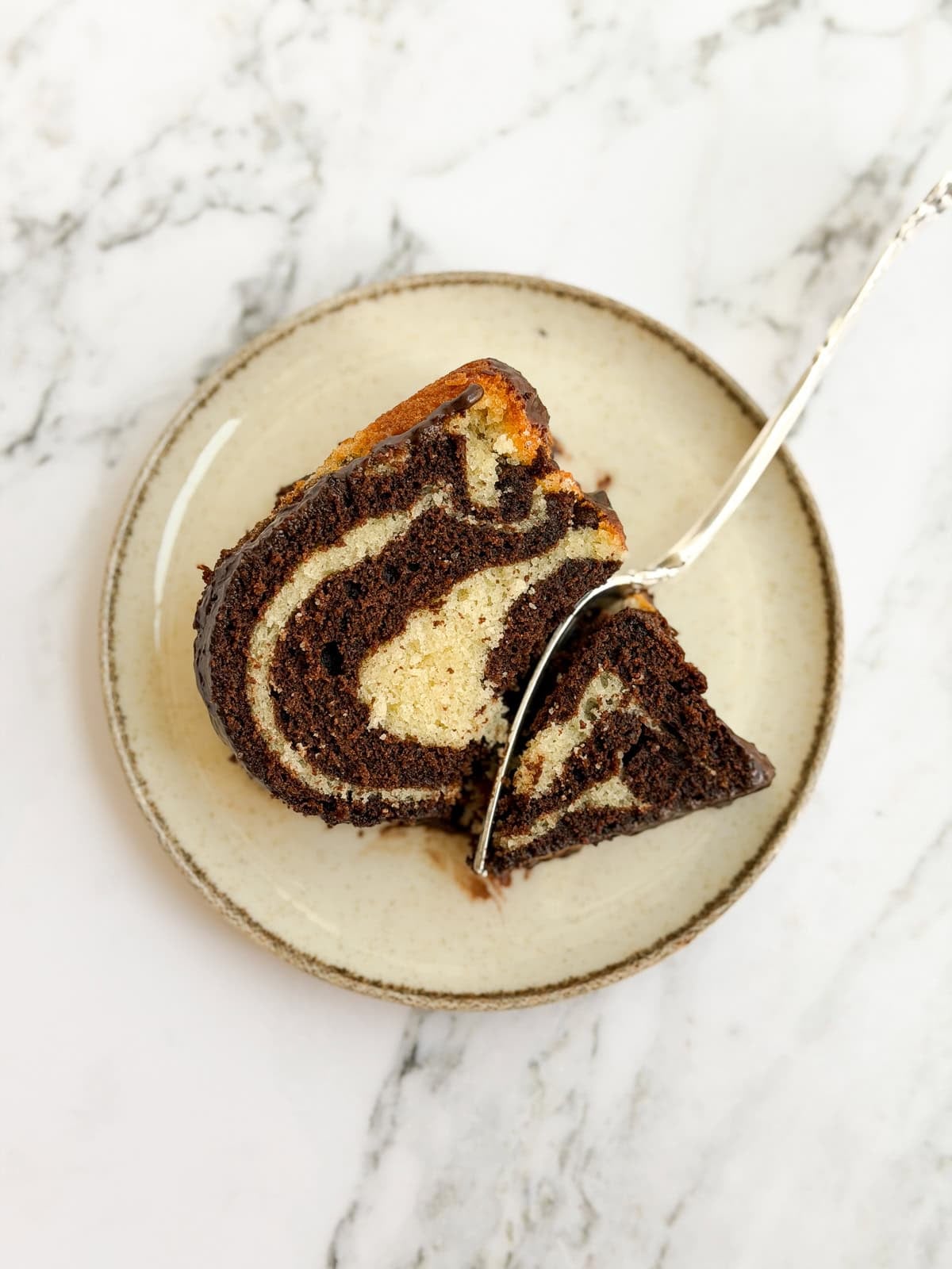 a slice of marble bundt cake with a fork in it.