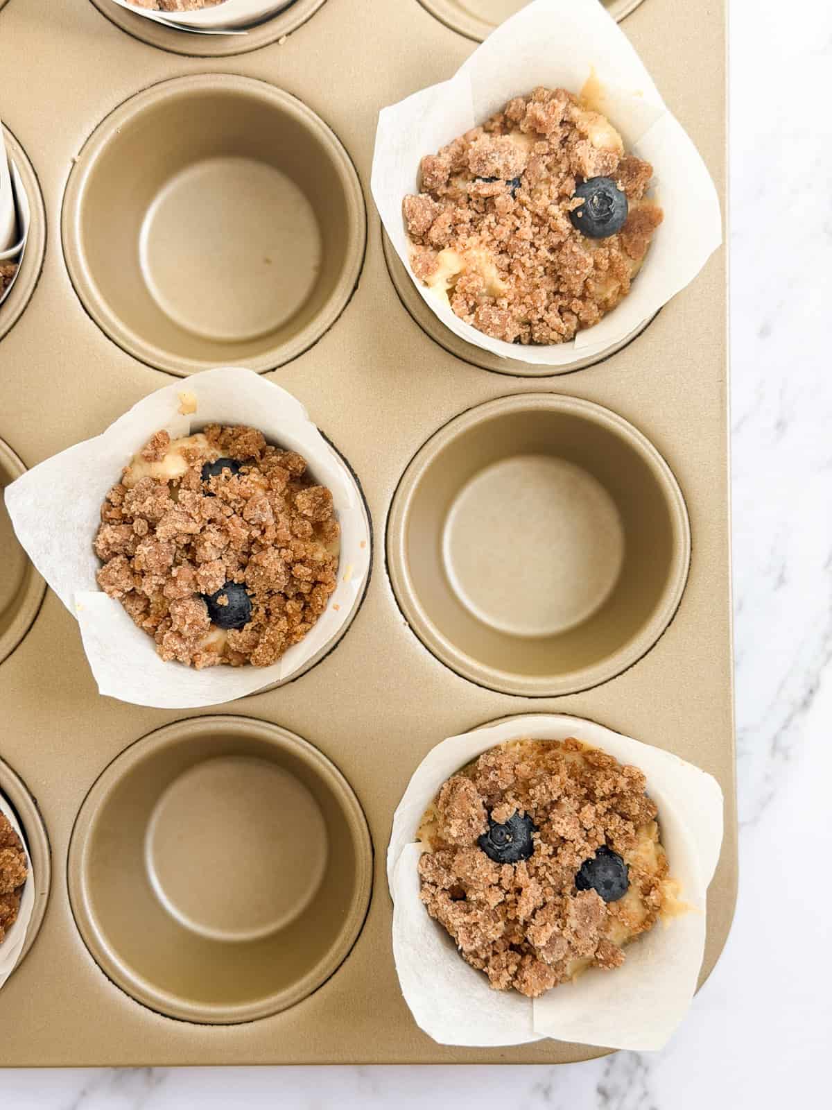 muffin batter in muffin tin before baking.
