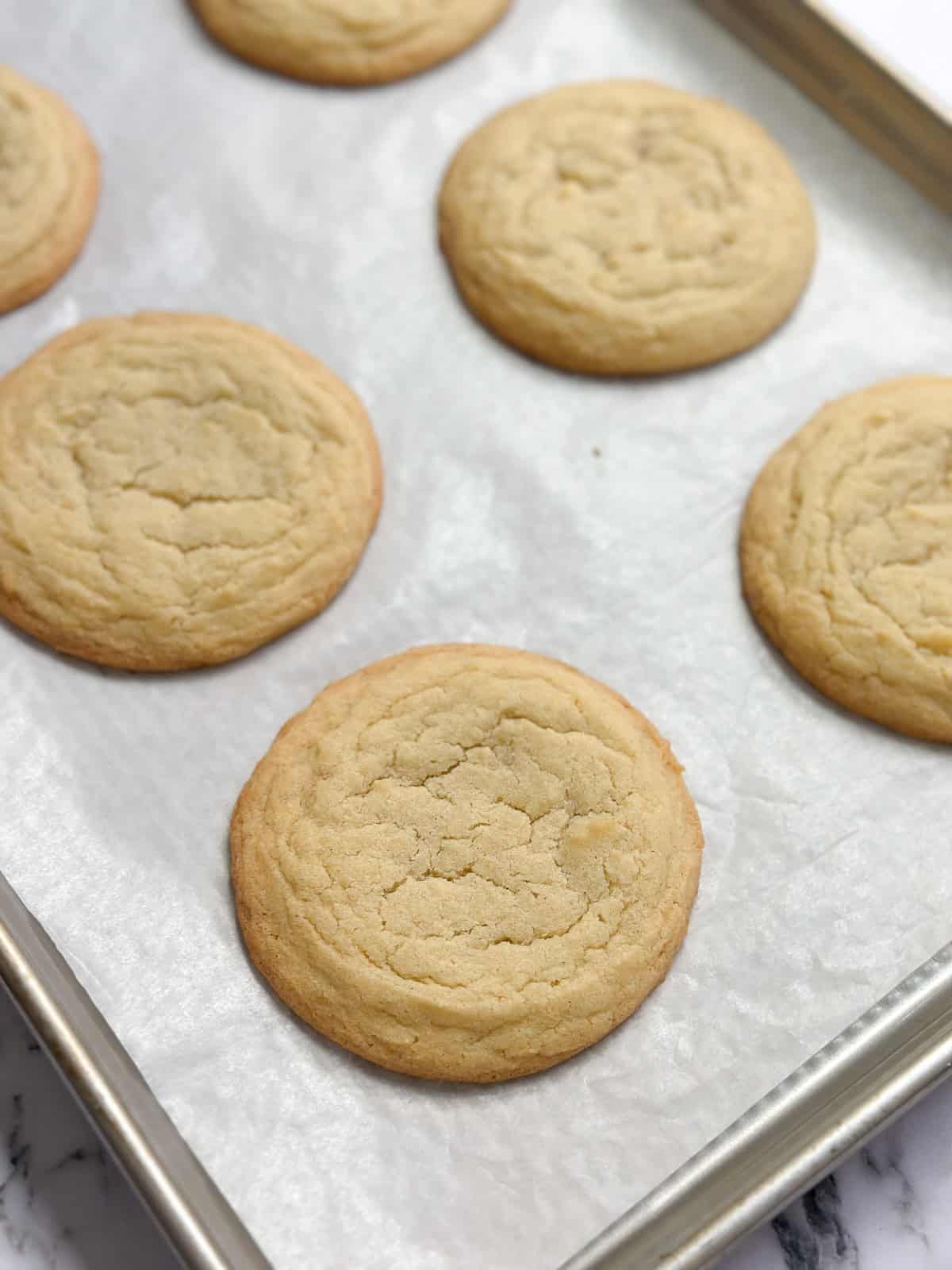 a sheet pan filled with sugar cookies before topping.