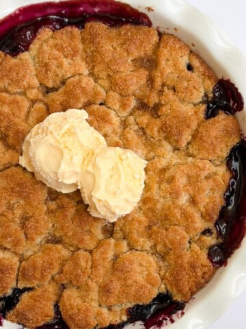 the whole pan of blueberry peach cobbler with scoops of ice cream on top.