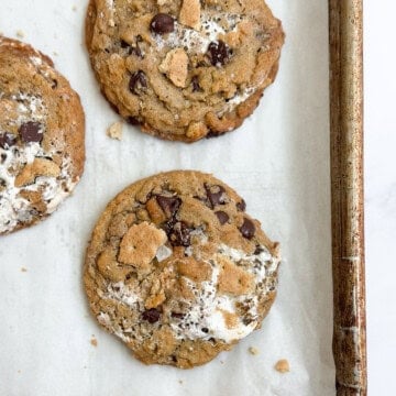 a few of the brown butter s'mores chocolate chip cookies on a baking sheet.