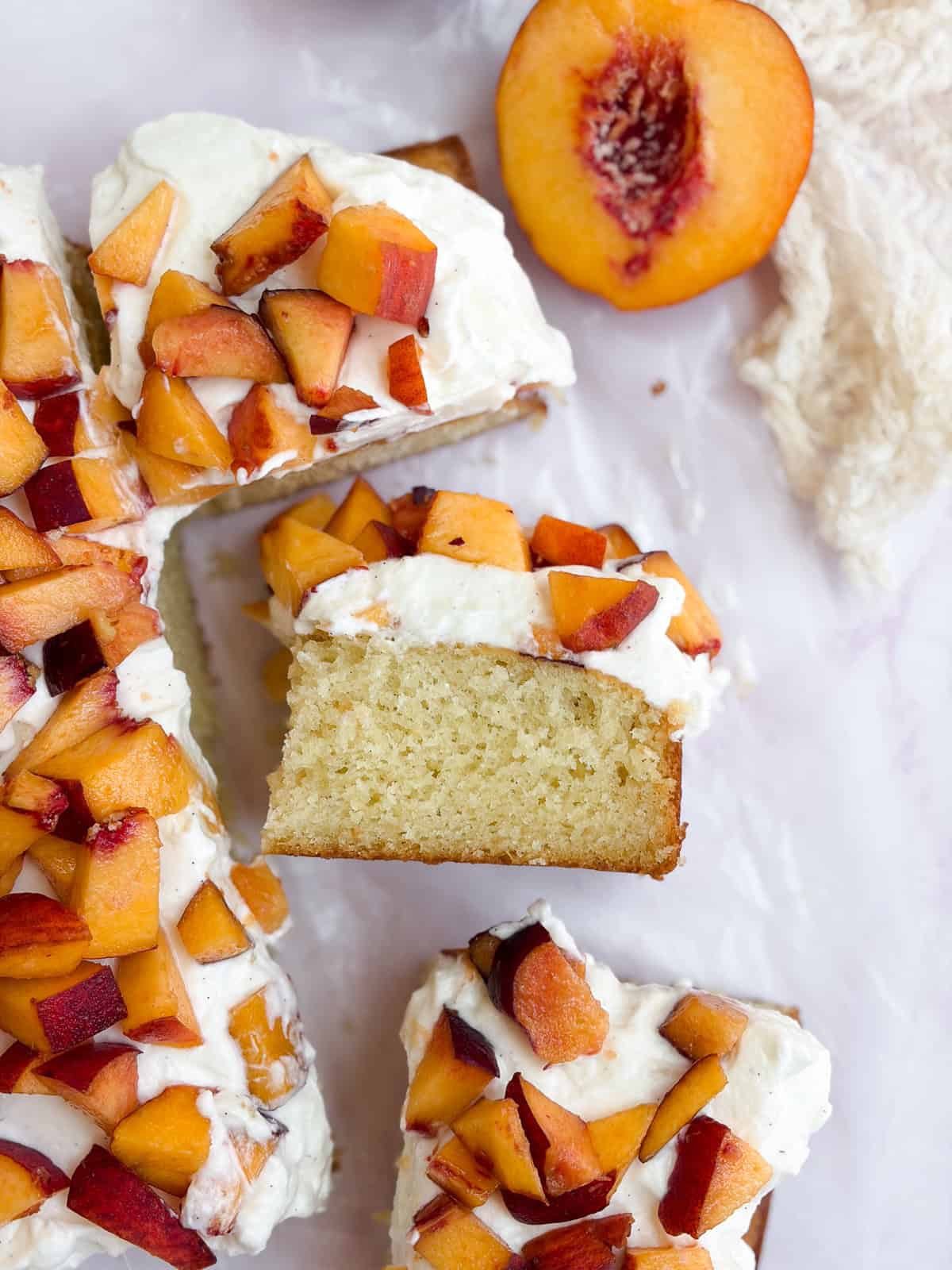 peaches and cream cake with one piece on its side so you can see the layers.