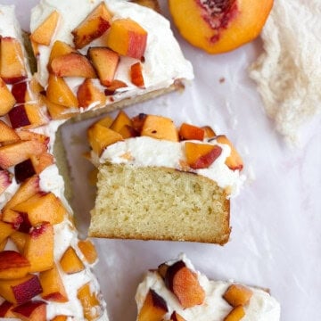 peaches and cream cake with one piece on its side so you can see the layers.