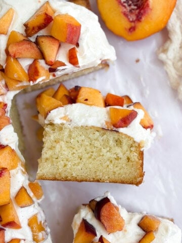 peaches and cream cake with one piece on its side so you can see the layers.